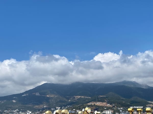 Morning coffee break captured on Alanya rooftop overlooking cityscape