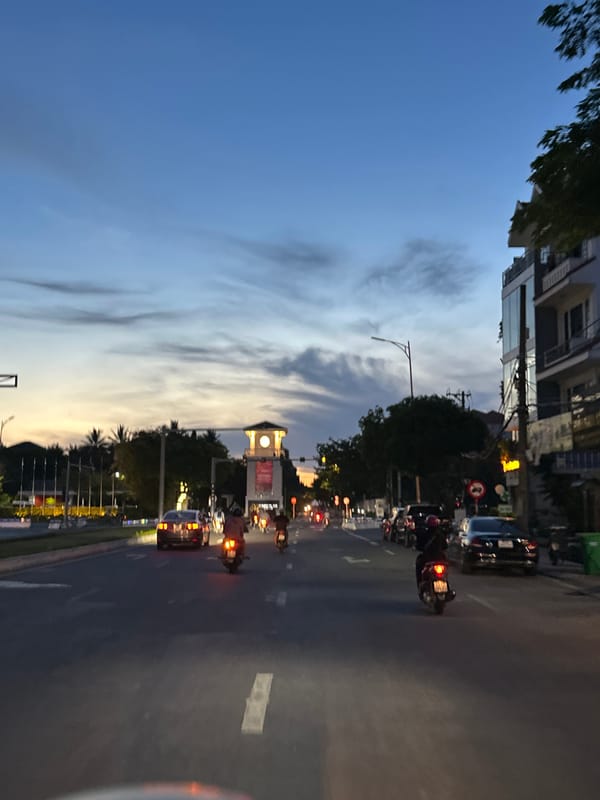 Da Nang intersection at dusk, traffic flowing under twilight skies