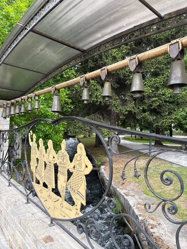 Tourist rings traditional cowbells at decorated display in Razlog