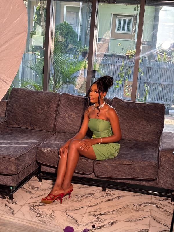 Lime green dress, pearls, and a gray sofa in Nigeria