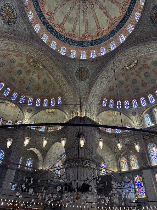 Morning tourists photograph Blue Mosque interior and exterior in Istanbul