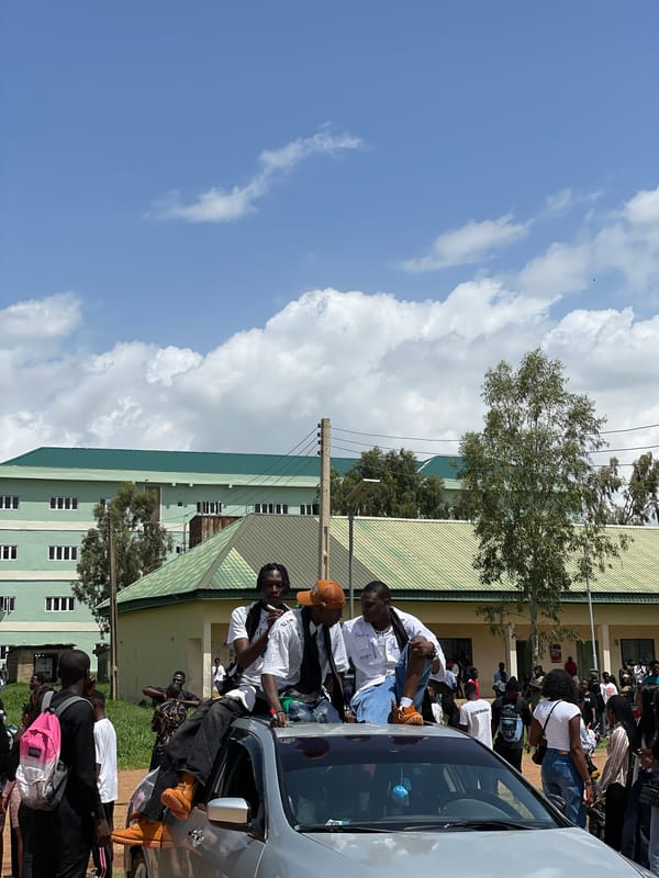 Outdoor celebration gathering around cars on a Nigerian campus