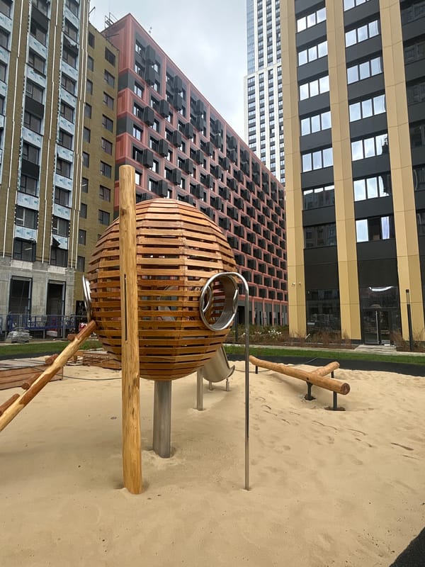 Modern buildings, playgrounds, and garden paths in an urban setting