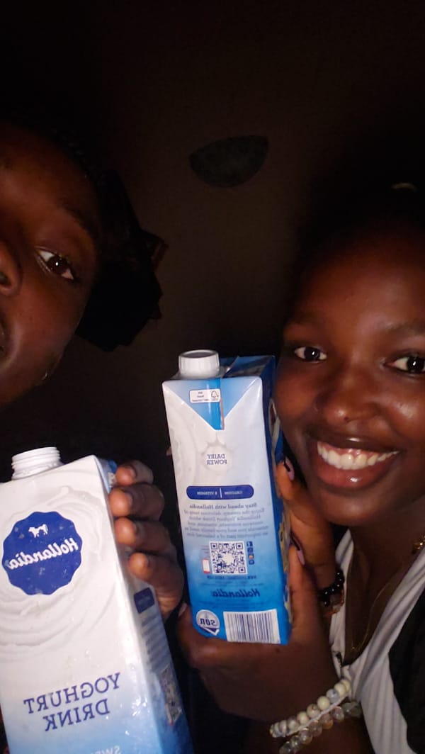 Two people photographed with dairy cartons in Rido, Nigeria