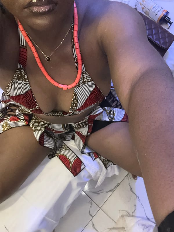 Patterned bikini and coral necklaces, indoors in Nyanya