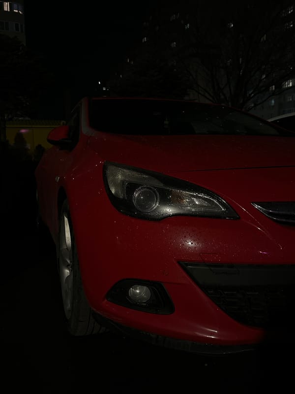Red car parked on wet street in Russia