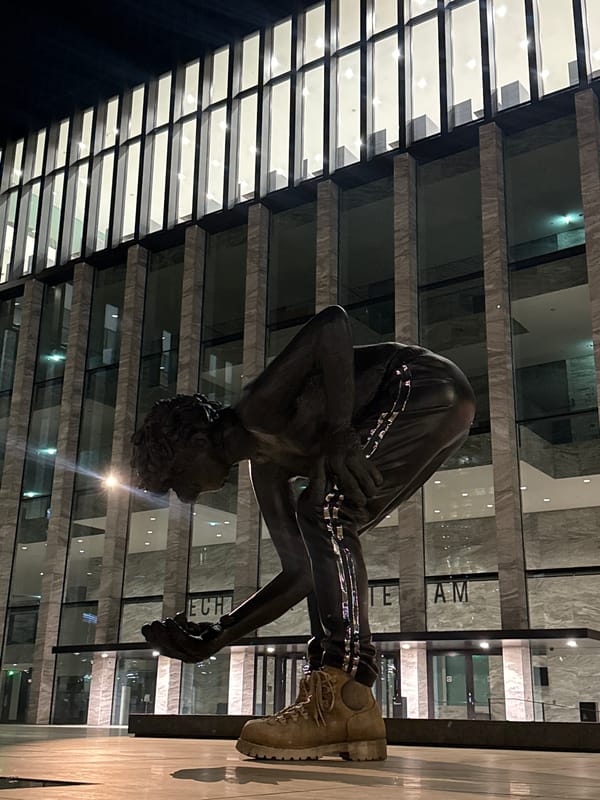 Bronze sculpture of crouching figure observed in Amsterdam