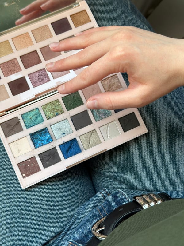 Person applies makeup using colorful eyeshadow palette in Russia