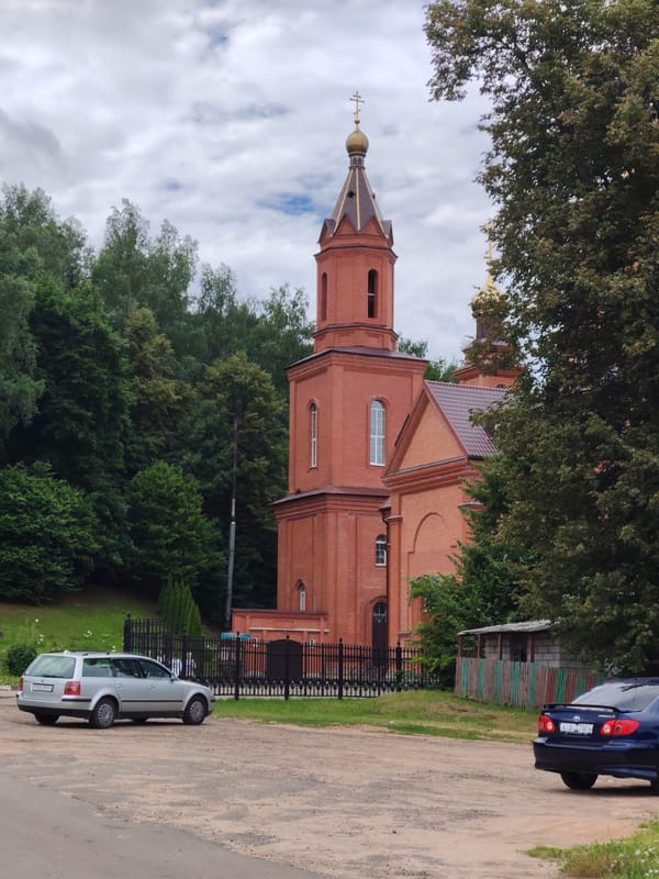 Red brick Orthodox church with golden dome in rural Belarus