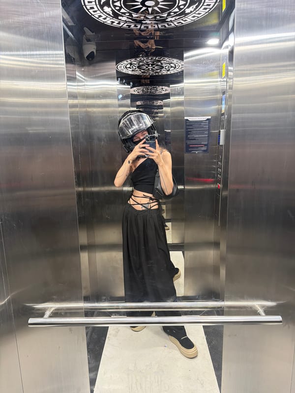 Woman in clear helmet photographs inside elevator in Đà Nẵng