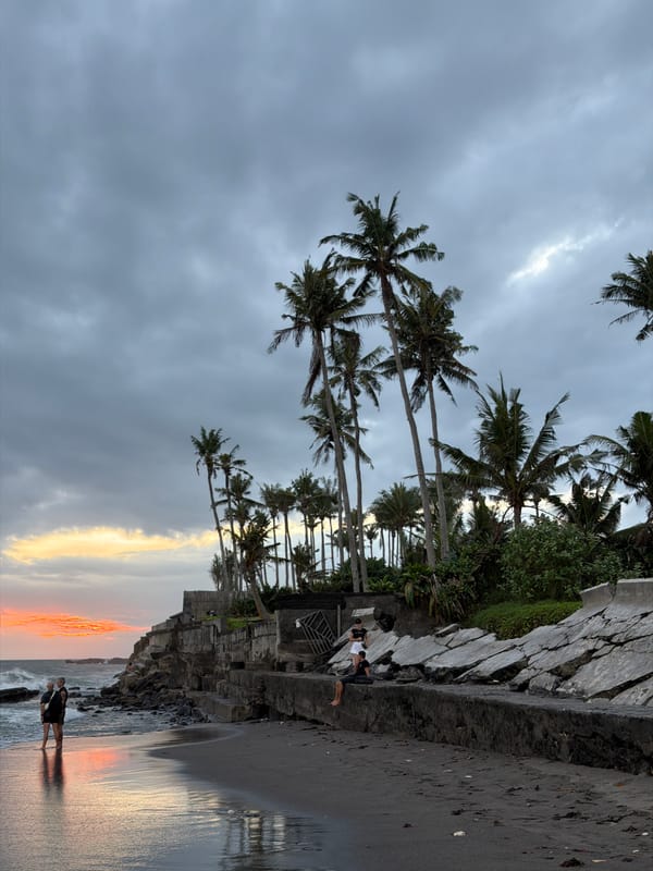 Beach life continues under dramatic sunset skies in Mengwi