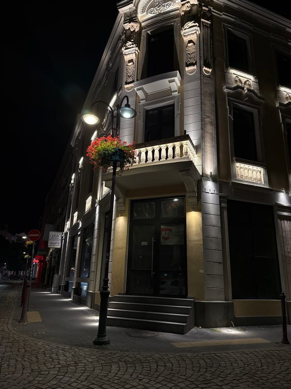 Ornate illuminated building at a Burgas street corner at night