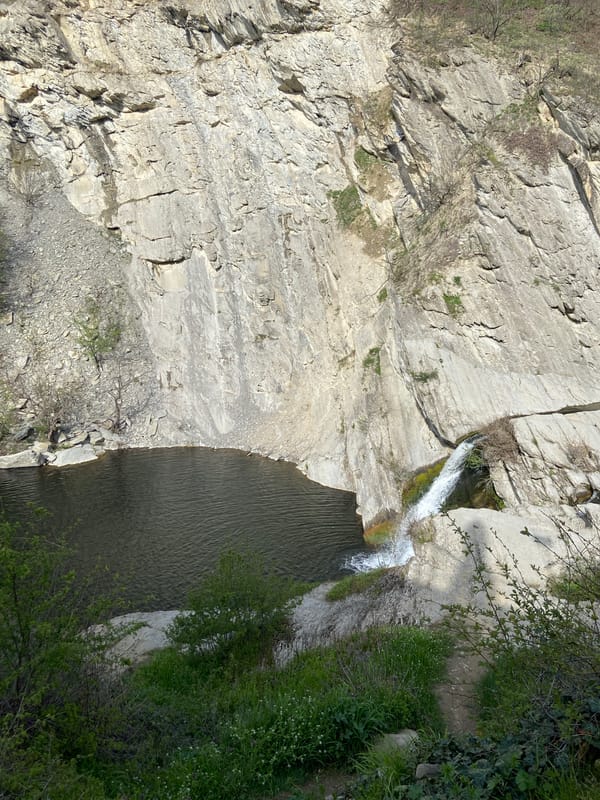 Cyclist documents waterfalls and stretching near Bulgarian monastery