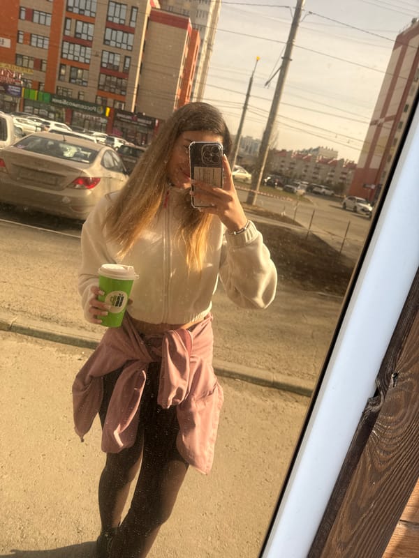Woman takes coffee shop selfies with green cup
