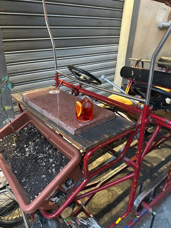 Red vendor cart spotted near shuttered storefront in Florence