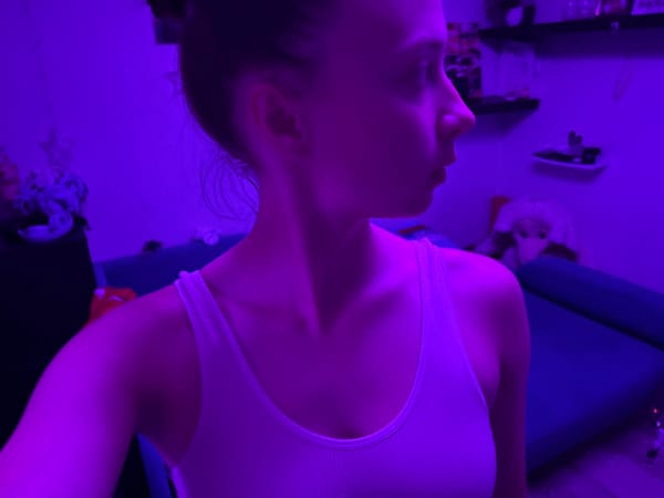 Woman observed in purple-lit room in Прикамский, Russia