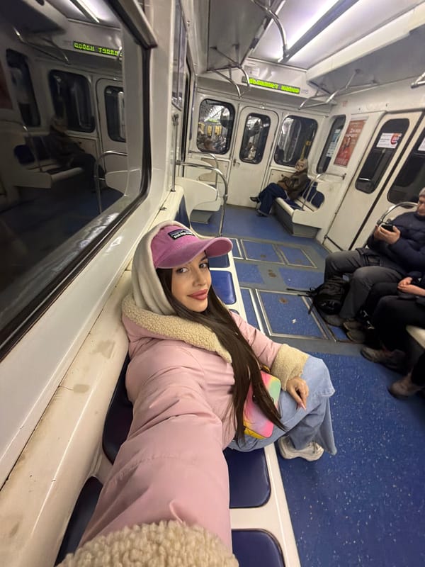 Woman in pink outfit poses on Saint Petersburg metro train