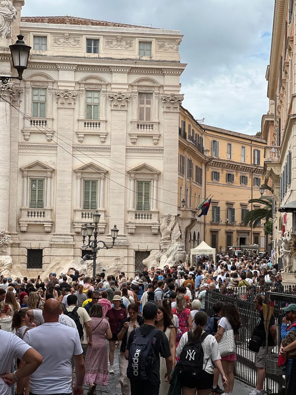 Crowds gather at Rome's Trevi Fountain during overcast afternoon