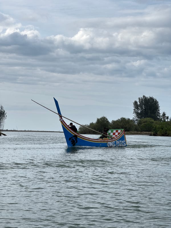 Colorful traditional longboats navigating a river in Rhieng Mancang
