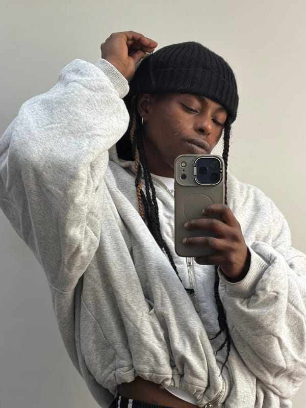 Person takes selfie in grey hoodie against wall in London