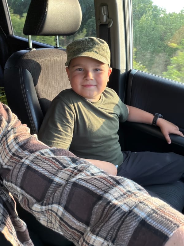 Boy photographed smiling in car backseat in Sergeyevka, Russia