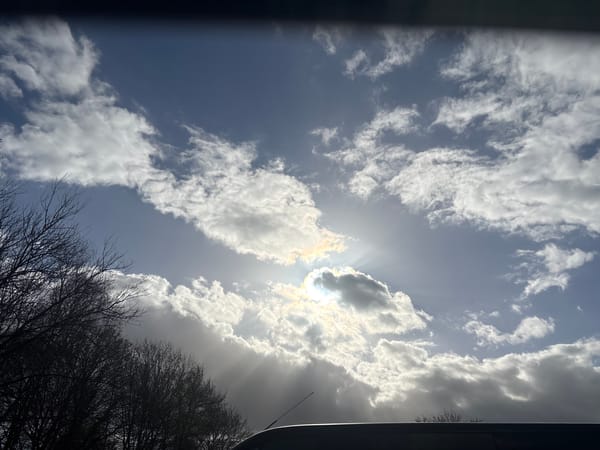 Sunlight breaks through clouds over Mole Valley countryside