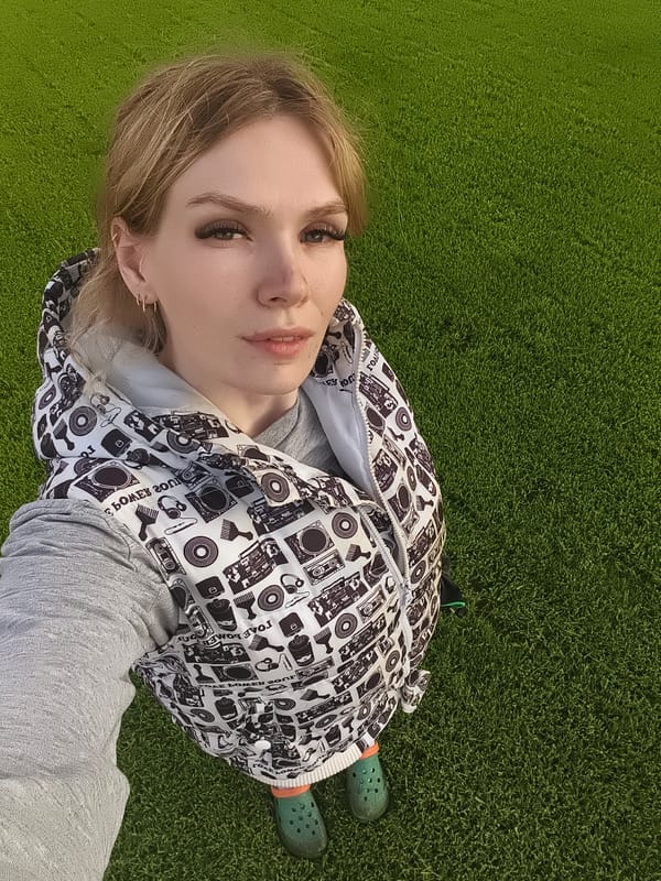 Woman takes selfies, man trims grass in Russian village