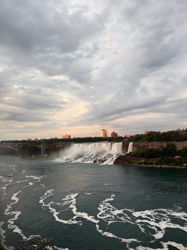 Horseshoe Falls at dusk, mist rising, buildings on the ridge