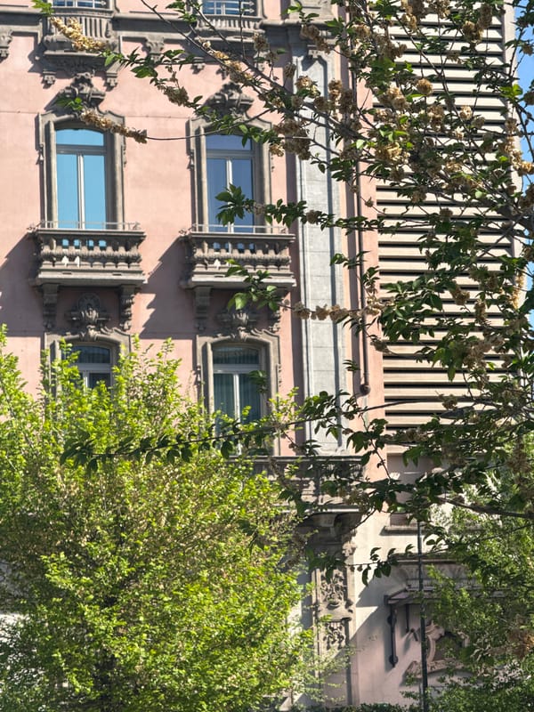 Milan morning moments: pink building facade, indoor escalator ride