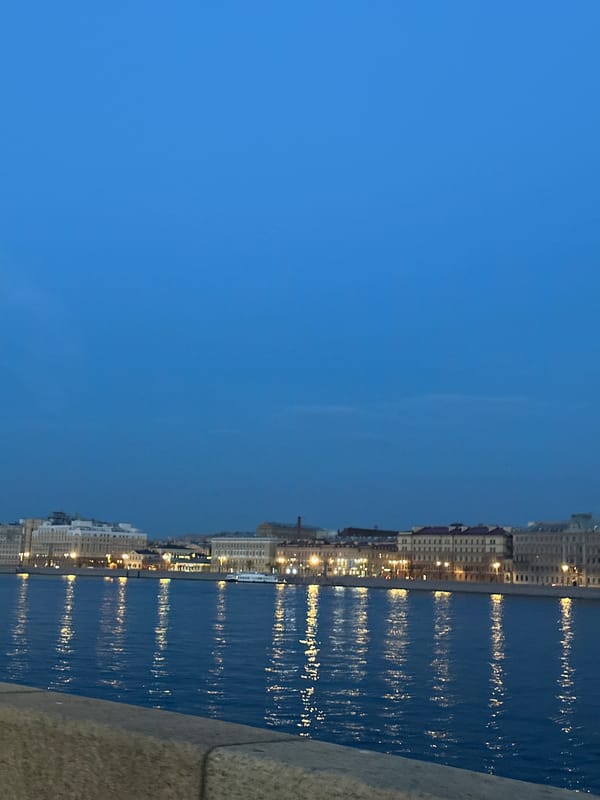 Dusk waterfront cityscape observed with reflective river lights