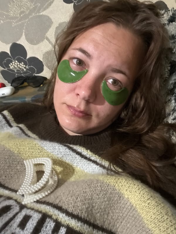 Person uses green under-eye patches during nighttime skincare routine