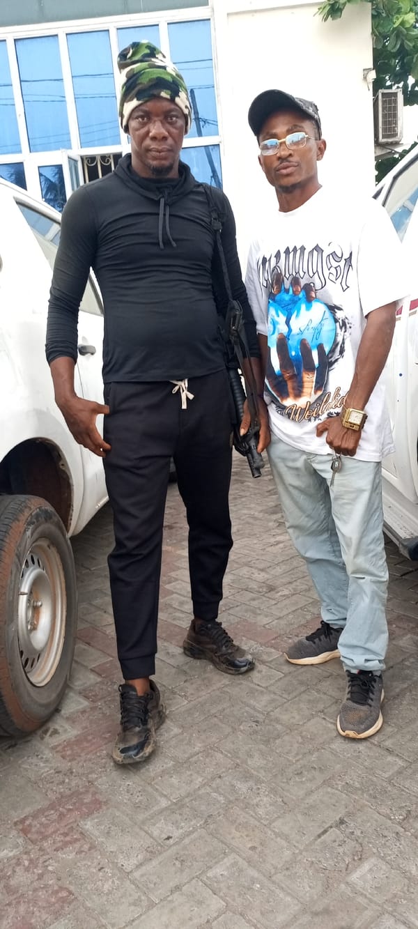 Two men photographed outside white building in Lokoja, Nigeria