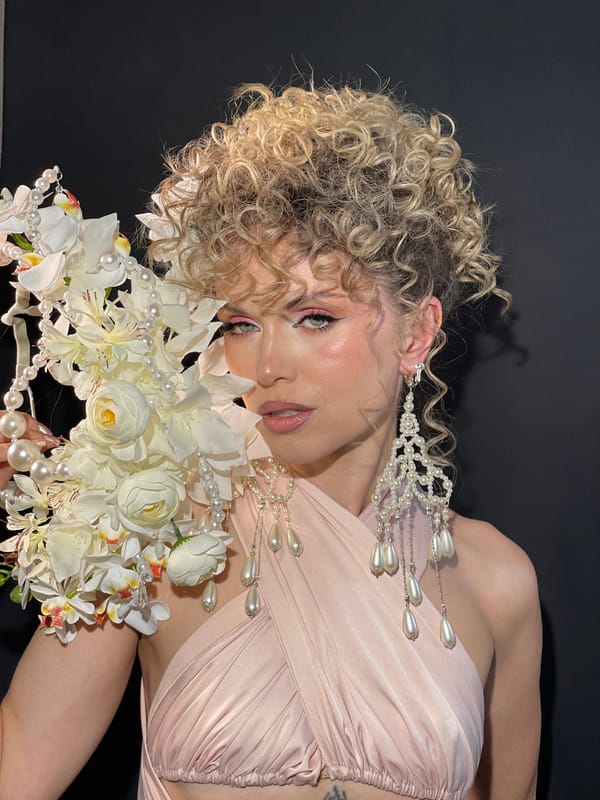 Woman in pink dress poses with flowers in Kazan