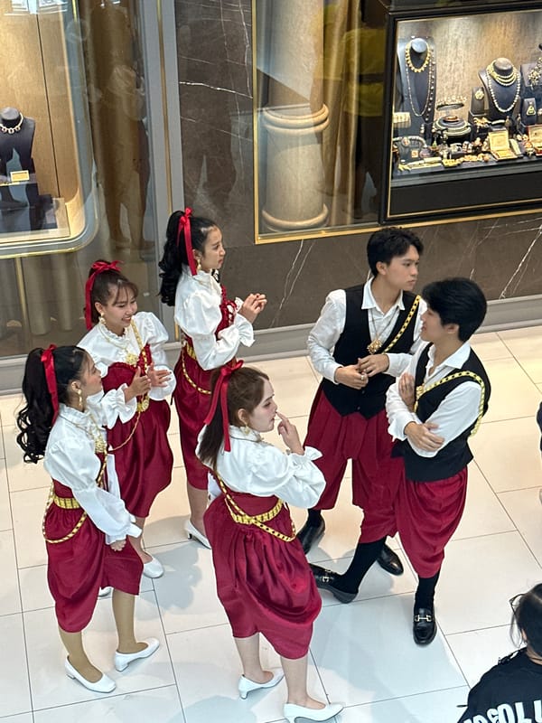 Traditional dancers perform in Bangkok shopping mall near jewelry store