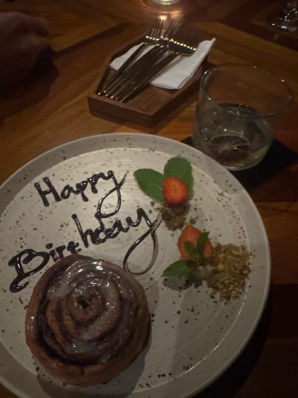 Birthday cinnamon roll celebration captured at restaurant