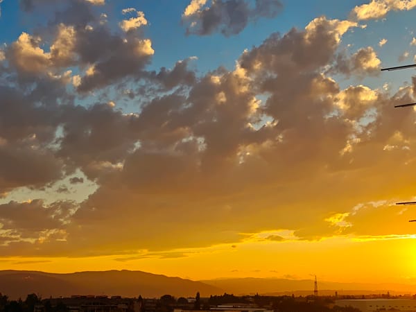 Tbilisi skyline at golden hour, clouds and crescent moon