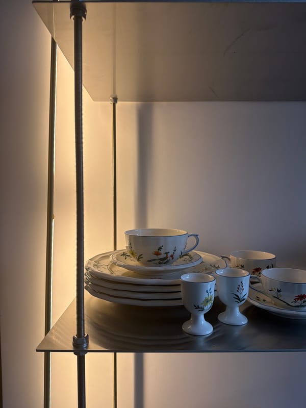 White ceramic dinnerware collection displayed on modern shelving unit