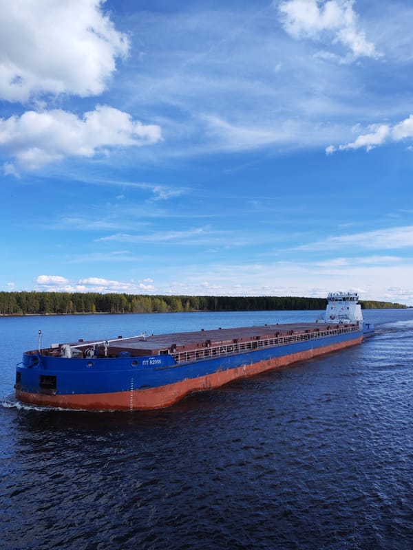 Tugboat tows cargo barge through Russian waterway near Topornya