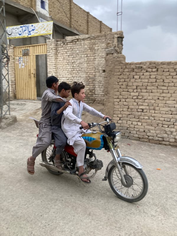 Two girls photographed near calligraphic wall in Quetta