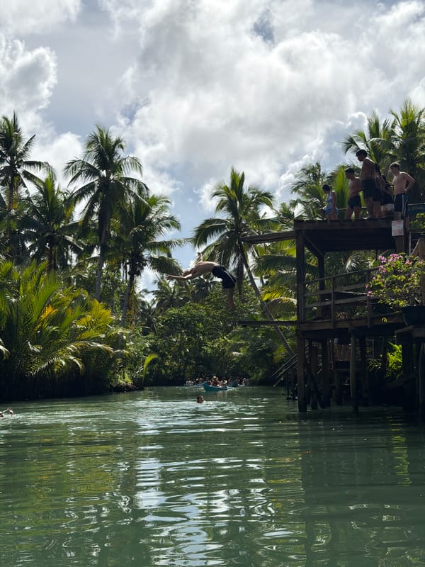 Man dives from wooden structure in Dapa, Philippines