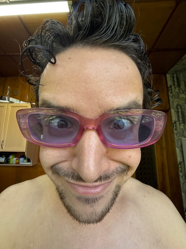Man tries on multiple sunglasses indoors in Tashkent