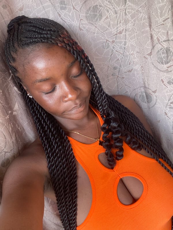 Woman poses for photos in orange top, Rido Nigeria