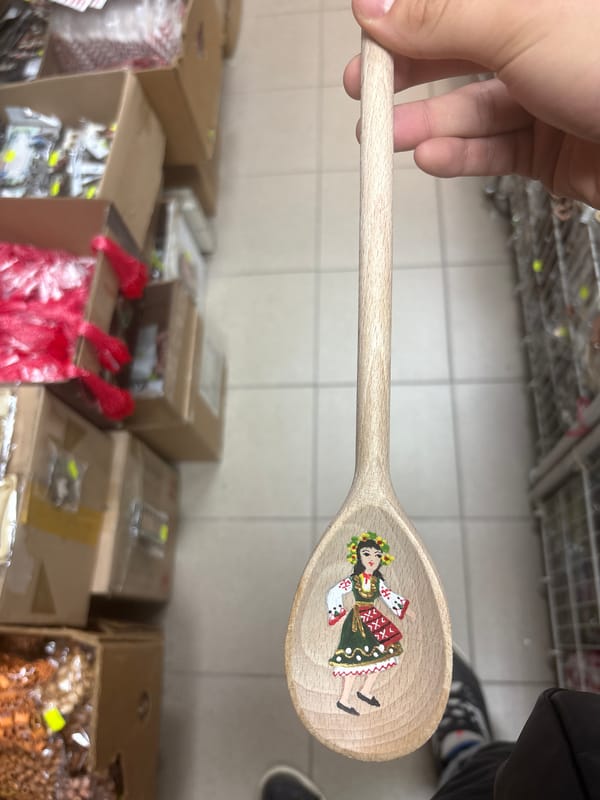 Traditional Bulgarian figurine displayed on wooden spoon in Sofia shop