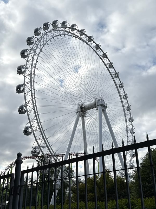 White Ferris wheel with enclosed pods under cloudy Saint Petersburg sky