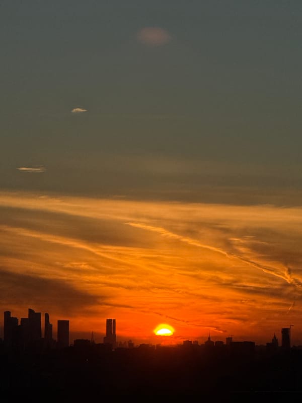 Moscow sunset bleeds from sky into a glowing hallway door