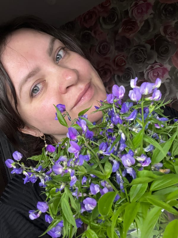 Woman photographed in domestic settings with purple flowers in Russia