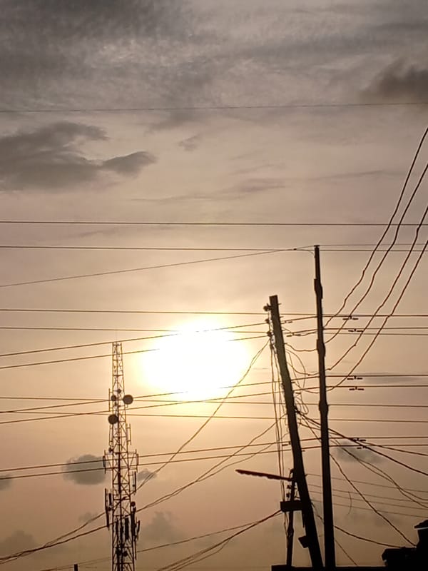 Urban sunset captured with power lines and cell tower