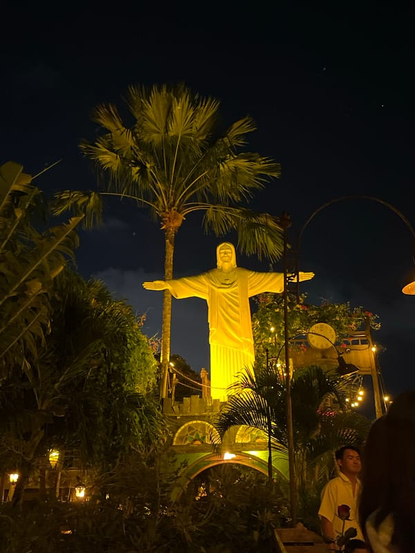 Kuta after dark: lit streets, vintage lamps, and a glowing statue
