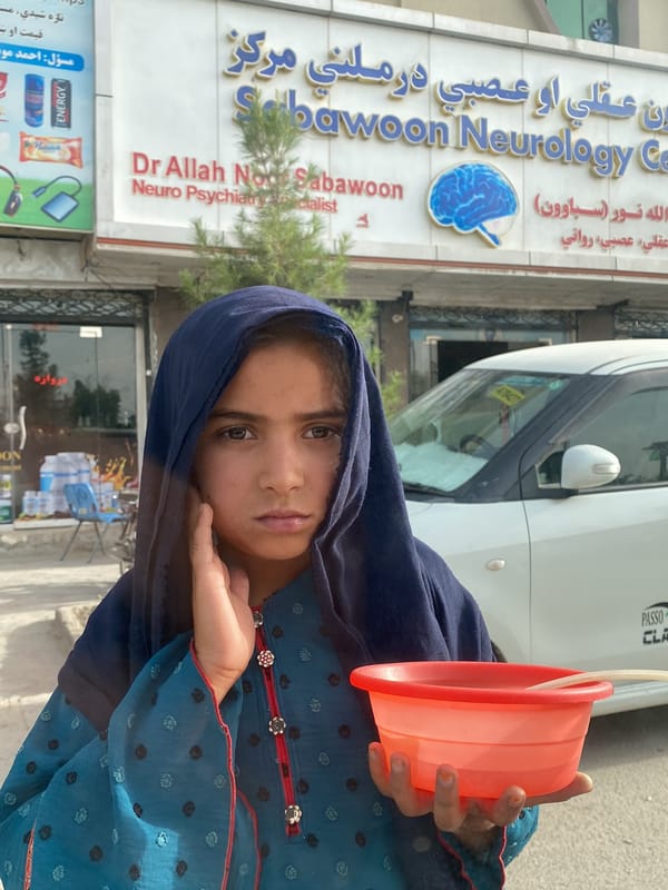Child with bowl observed outside building in Kandahar