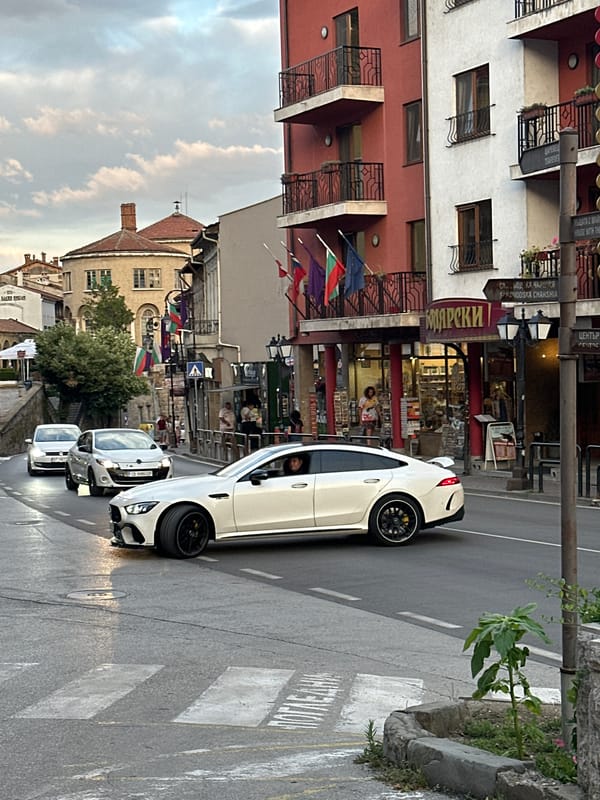 Two luxury cars moving through Veliko Tarnovo streets at dusk